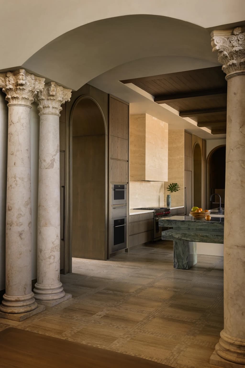 Kitchen framed by classical columns and plaster architecture