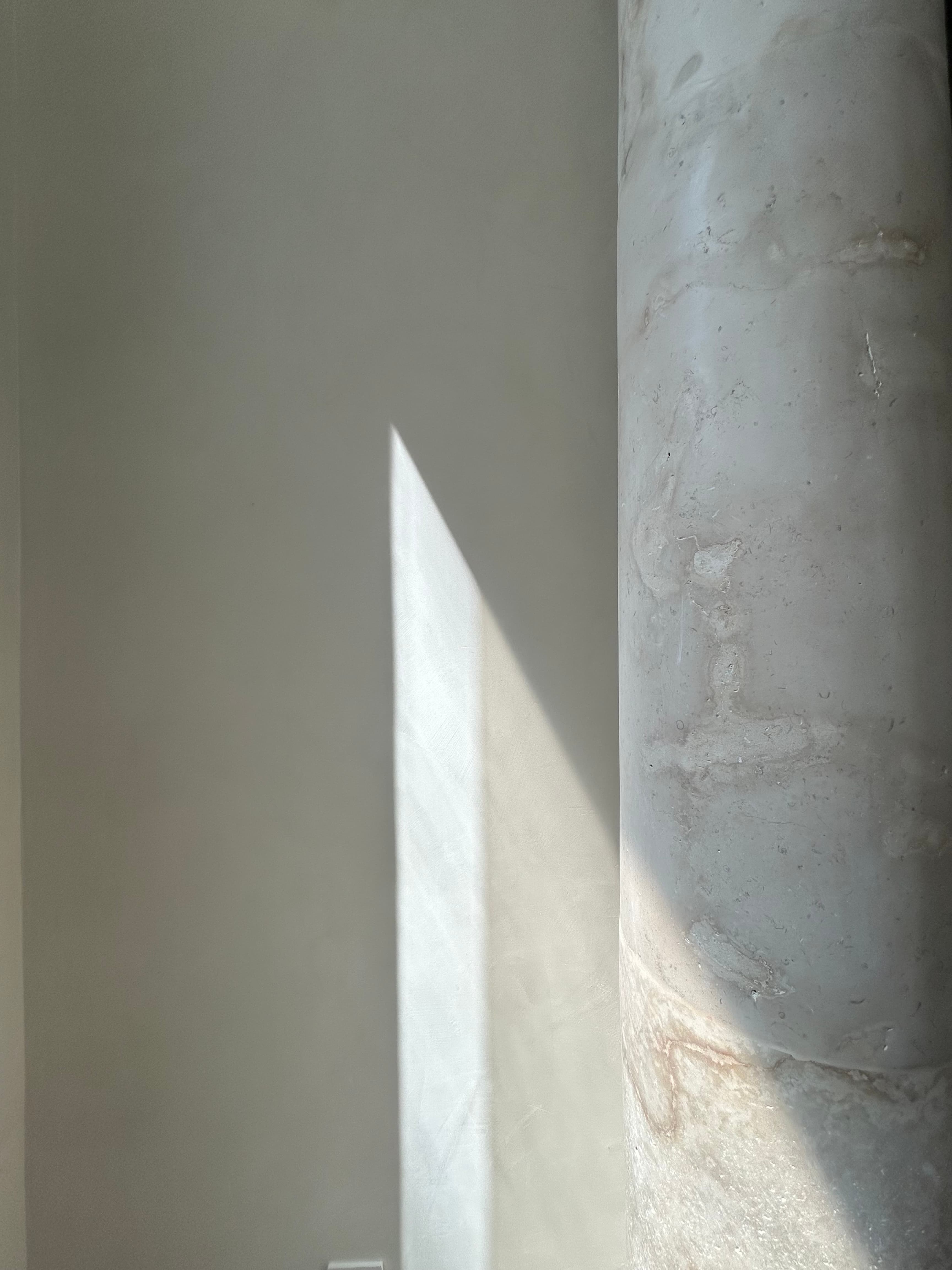 Natural light and mineral surface beside a stone column